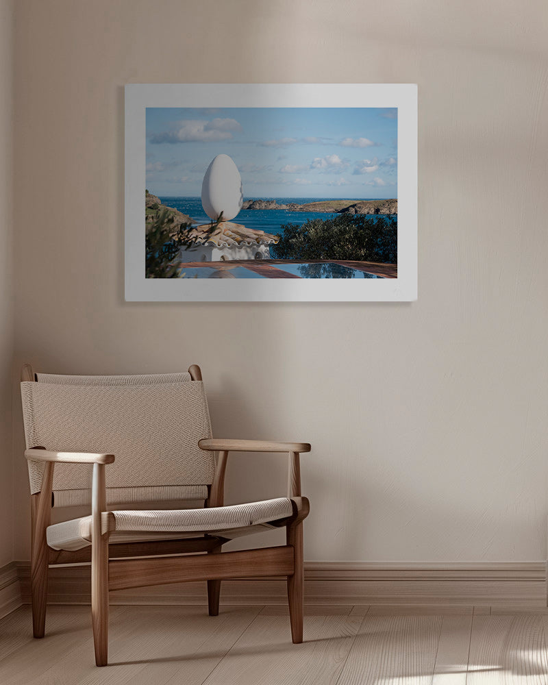 Landscape art featuring an egg sculpture by the sea