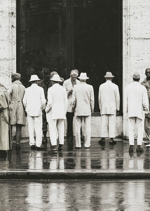 Fotografía en blanco y negro de hombres bajo la lluvia